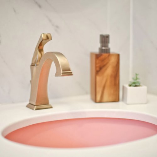 Pink sink and gold fixtures.